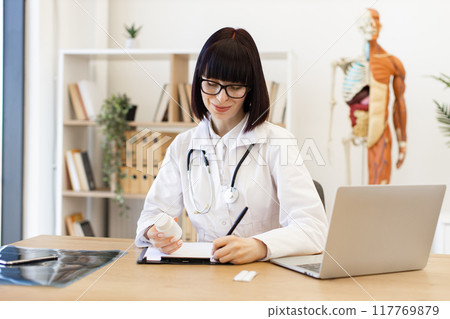 Female doctor writing prescription in medical office Female doctor writing prescription in medical office 117769879