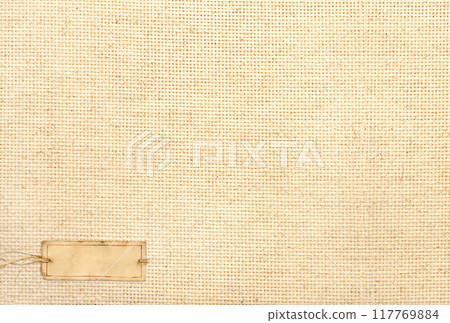 Organic eco paper tag on Natural linen texture. Eco-friendly background with paper label on canvas. Sustainable development of strategy approach to zero waste, responsible consumption. Go green 117769884