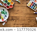 Top view above creative desk. Watercolor paints on wooden table. 117770326