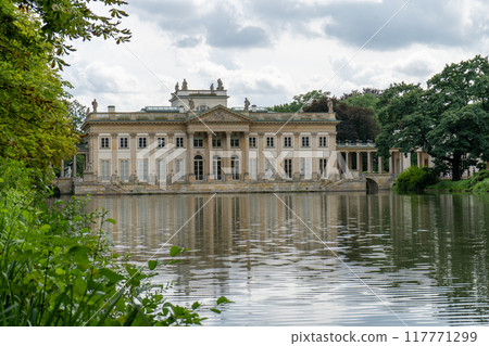Lazienki Park with pond. Polish Lazienkowski or Lazienki Krolewskie is the polish park. The palace on the water is a monument of architecture. 117771299