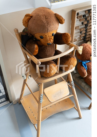 Old toy bear. Wooden high chair for children and baby. Ragdoll. Teddy bear 117771385