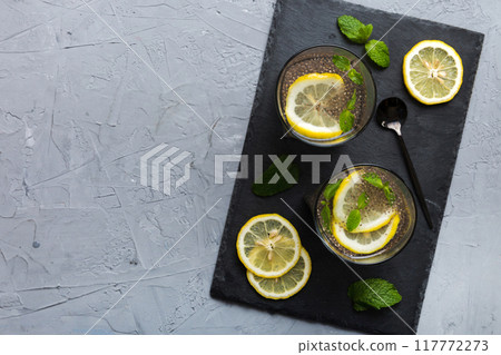 Healthy breakfast or morning with chia seeds lemon and mint on table background, vegetarian food, diet and health concept. Chia pudding with lemon and mint Healthy breakfast or morning with chia seeds lemon and mint on table background, vegetarian food, diet and health concept. Chia pudding with lemon and mint 117772273