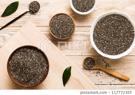 Chia seeds in bowl and spoon on colored background. Healthy Salvia hispanica in small bowl. Healthy superfood Chia seeds in bowl and spoon on colored background. Healthy Salvia hispanica in small bowl. Healthy superfood 117772305