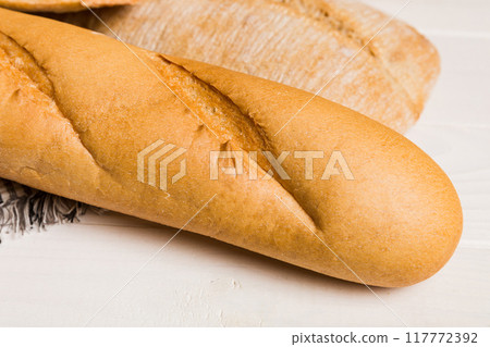 Homemade natural breads. Different kinds of fresh bread as background, perspective view with copy space Homemade natural breads. Different kinds of fresh bread as background, perspective view with copy space 117772392