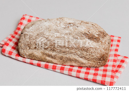 freshly baked bread with napkin on rustic table top view. Healthy white bread loaf isolated 117772411