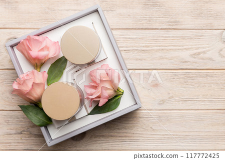 Composition with cosmetic products and beautiful roses on wooden background. Copy space, flat lay Composition with cosmetic products and beautiful roses on wooden background. Copy space, flat lay 117772425