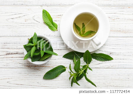 Cup of mint tea on table background. Green tea with fresh mint top view with copy space 117772454