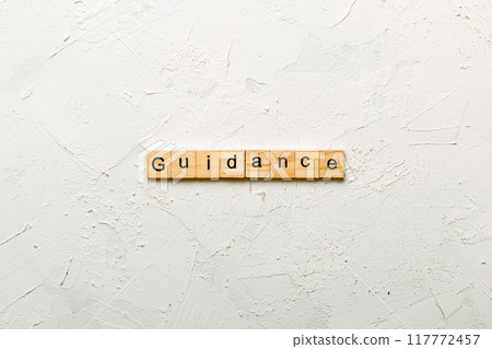 Guidance word written on wood block. Guidance text on table, concept 117772457