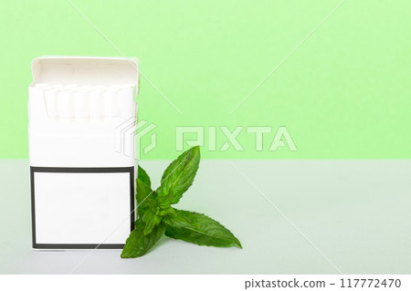 Pack of menthol cigarettes and fresh mint on colored table, Menthol cigarettes top view flat lay 117772470