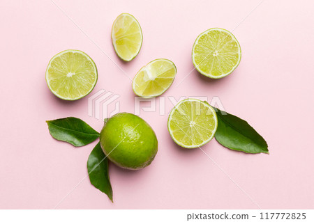 Lime fruits with green leaf and cut in half slice isolated on white background. Top view. Flat lay with copy space 117772825