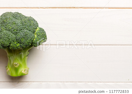 Top view fresh green broccoli vegetable on Colored background. Broccoli cabbage head Healthy or vegetarian food concept. Flat lay. Copy space 117772833