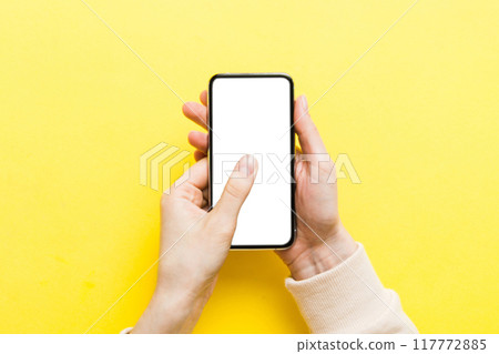 Top view of woman hands holding smart phone with blank copy space screen for your text message or information content. woman hand using phone white screen on top view Top view of woman hands holding smart phone with blank copy space screen for your text message or information content. woman hand using phone white screen on top view 117772885
