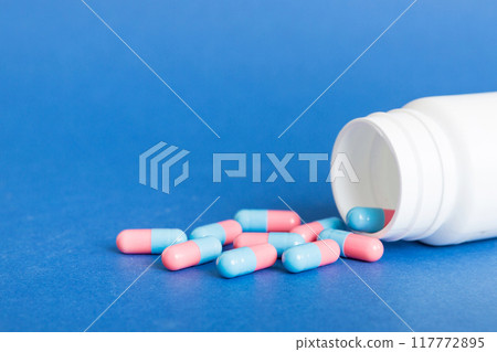 plastic medicine bottle with capsules of pills on colored background. Online pharmacy. Painkiller medicine and antibiotic drug resistance concept. Pharmaceutical industry plastic medicine bottle with capsules of pills on colored background. Online pharmacy. Painkiller medicine and antibiotic drug resistance concept. Pharmaceutical industry 117772895