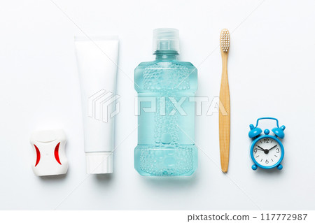 Mouthwash and other oral hygiene products on colored table top view with copy space. Flat lay. Dental hygiene. Oral care products and space for text on light background. concept 117772987
