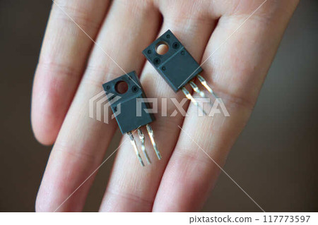 Close up of a semiconductor transistor on a hand Close up of a semiconductor transistor on a hand 117773597