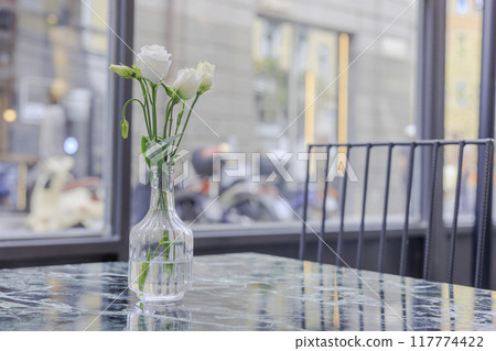 White flowers in a glass vase 117774422