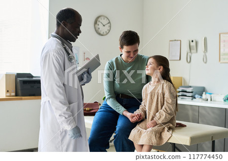 Doctor Consulting Patient in Medical Examination Room 117774450