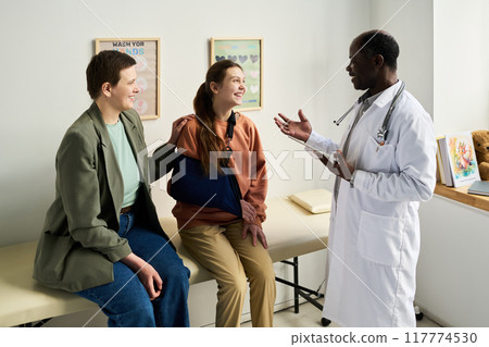 Doctor Discussing with Injured Patient in Medical Office 117774530