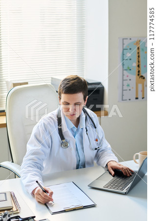Portrait of Female Doctor Reviewing Patient Records 117774585