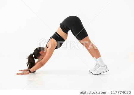 Smiling healthy woman doing yoga at home. white background 117774620