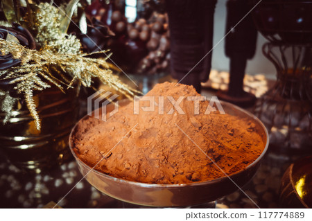 Cocoa powder in a metal cup on a rustic table Cocoa powder in a metal cup on a rustic table 117774889