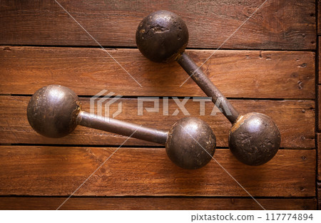 Old rusty dumbbells on wood background texture 117774894