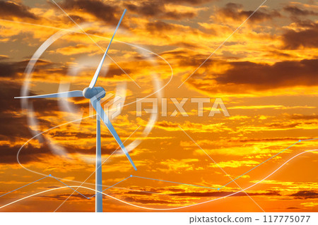 A wind turbine is spinning in the sky above a sunset 117775077