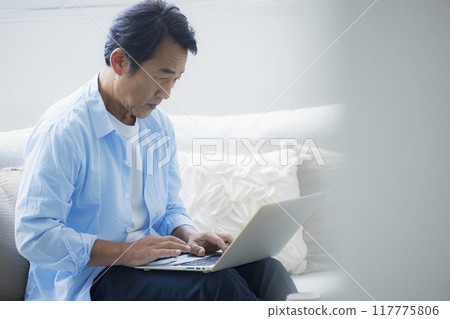 中年男子在客廳使用筆記型電腦 117775806