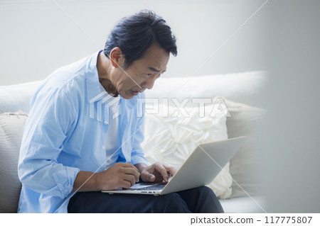中年男子在客廳使用筆記型電腦 117775807