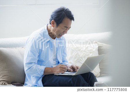 中年男子在客廳使用筆記型電腦 117775808