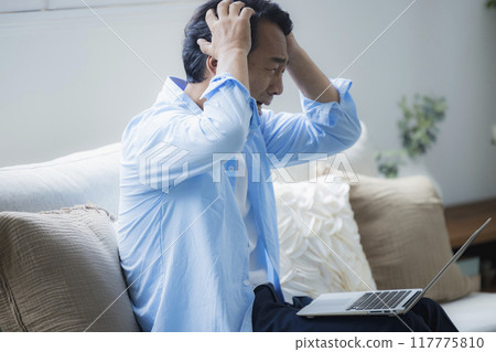 中年男子在客廳使用筆記型電腦 中年男子在客廳使用筆記型電腦 117775810