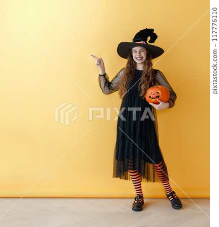 girl in witch costume with Halloween pumpkin girl in witch costume with Halloween pumpkin 117776110