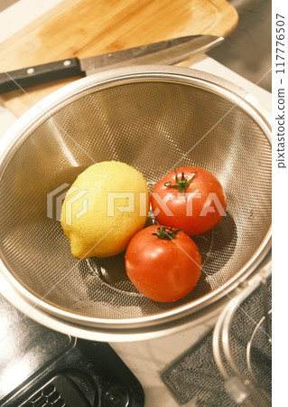 Cherry tomatoes and lemons lined up in the kitchen 117776507