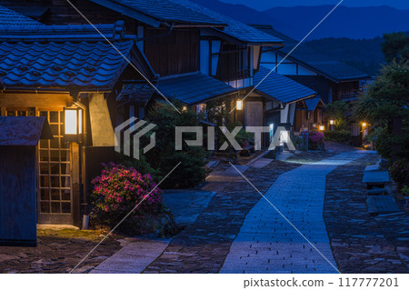日本：岐阜縣中津川市中山道宿間町馬遼宿的鵝卵石斜坡和燈火通明的夜間街道 117777201