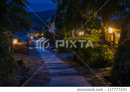 Japan: Stone-paved slopes and illuminated streetscape at night in Magome-juku, a post town on the Nakasendo road in Nakatsugawa City, Gifu Prefecture 117777203