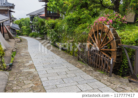 Japan: Stone-paved hillside, streetscape and waterwheel of Magome-juku, a post town on the Nakasendo road in Nakatsugawa City, Gifu Prefecture 117777417