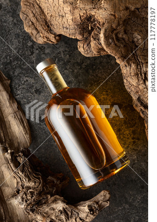 Bottle of whiskey and old dried snags. Bottle of whiskey and old dried snags. 117778197