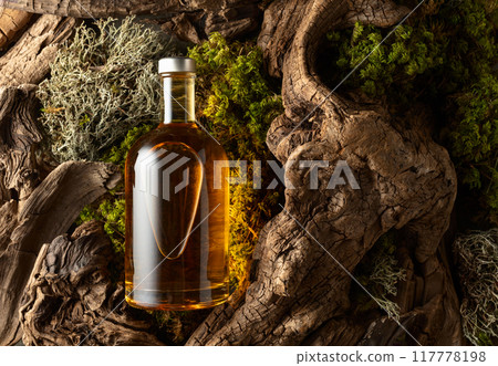 Bottle of strong alcoholic drink, old snags, and moss. Bottle of strong alcoholic drink, old snags, and moss. 117778198