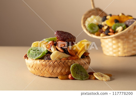 Dried tropical fruits, nuts and raisins on a beige background. 117778200