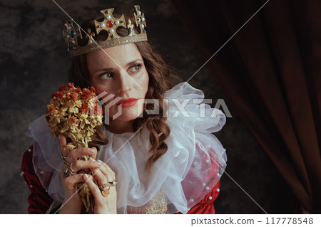 medieval queen in red dress with dried flower and white collar medieval queen in red dress with dried flower and white collar 117778548