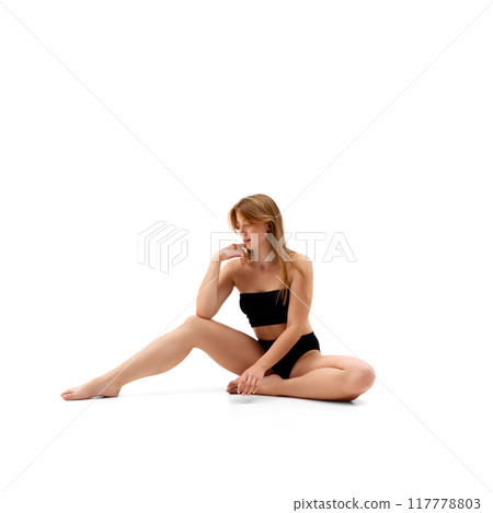 Portrait of attractive young woman with healthy sportive body, posing on floor in black underwear isolated on white background 117778803