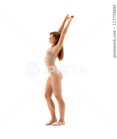 Full-length image of young beautiful woman with fit healthy body posing in underwear isolated on white background. Stretching. Full-length image of young beautiful woman with fit healthy body posing in underwear isolated on white background. Stretching. 117778892