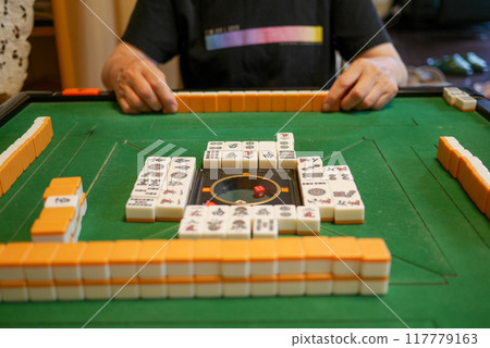 Playing mahjong at the electric mahjong table Playing mahjong at the electric mahjong table 117779163