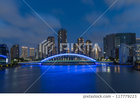 Japan: A night view of Tsukishima apartment complexes and the illuminated Eitai Bridge as seen from the Sumida River Bridge in Chuo Ward, Tokyo 117779223