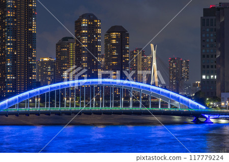 Japan: A night view of Tsukishima apartment complexes and the illuminated Eitai Bridge as seen from the Sumida River Bridge in Chuo Ward, Tokyo 117779224