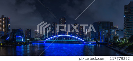 Japan: A night view of Tsukishima apartment complexes and the illuminated Eitai Bridge as seen from the Sumida River Bridge in Chuo Ward, Tokyo 117779252