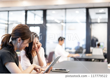 女性在有趣的氛圍中看著平板電腦螢幕 117779522