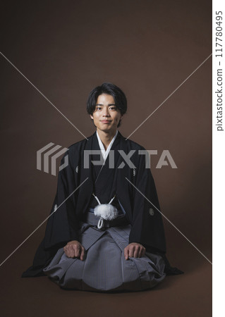 A young man in a crested hakama sitting upright 117780495