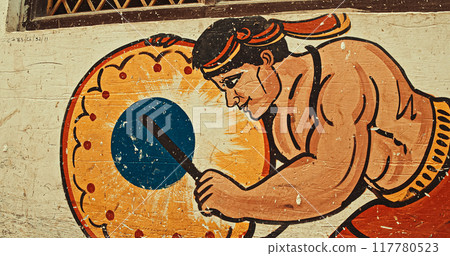 Varanasi, Uttar Pradesh, India. Street Graffiti Mural In Narrow Old Street Showing Man With Kanjira, Khanjira, Khanjiri Or Ganjira Is South Indian Frame Drum Is Instrument Of Tambourine Family. Varanasi, Uttar Pradesh, India. Street Graffiti Mural In Narrow Old Street Showing Man With Kanjira, Khanjira, Khanjiri Or Ganjira Is South Indian Frame Drum Is Instrument Of Tambourine Family. 117780523