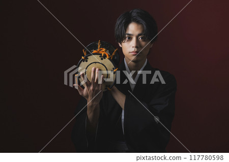 A man in a crested hakama playing a Japanese musical instrument A man in a crested hakama playing a Japanese musical instrument 117780598
